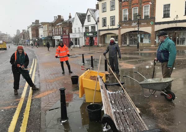 Councillors Harvey (left) and Morris (right) spread the grit on the High Street with volunteers