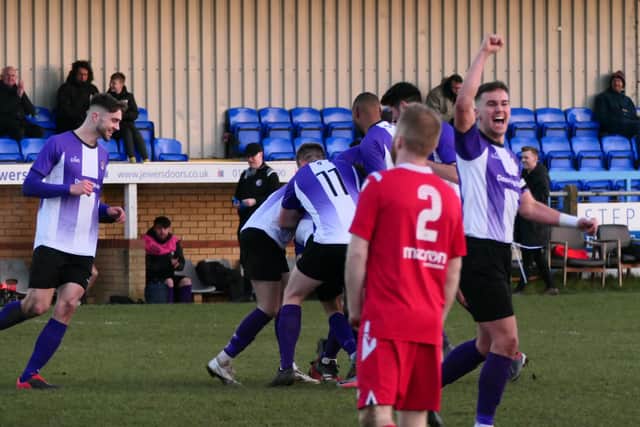 Captain Alfie Osborne celebrates as players mob Ross Adams, scorer of their third goal  Picture by Andrew Parker