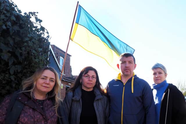 Four Ukrainians with the flag. Mykhaylo and his wife, Nataliya, are the two in the centre. Photo: Tony Margiocchi