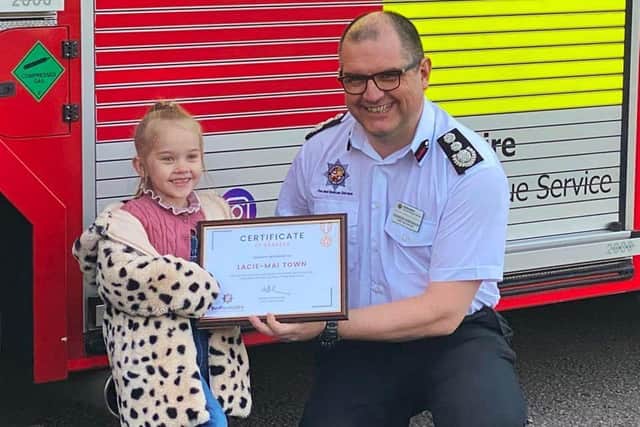 Lacie-Mai Town receives a bravery certificate from Chief Fire Officer Andrew Hopkinson