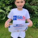 Proud seven-year-old Joshua Cowley with his Certificate of Appreciation from KidsOut