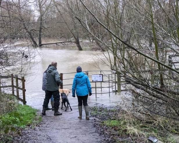 Walkers standing next to the River Ouzel when it overflowed in January. Photo: Phil Wood