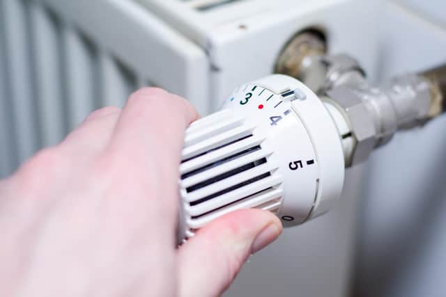 A person adjusts the temperature of a radiator. Picture: Adobe Stock