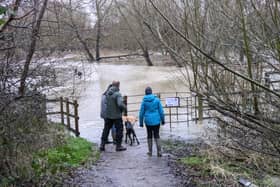 Walkers stand next to the overflowing River Ouzel. Photo: Phil Wood