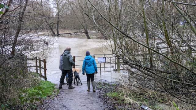 Walkers stand next to the overflowing River Ouzel. Photo: Phil Wood