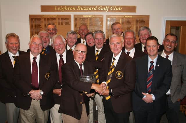 Leighton president Trevor Stimpson is joined by members of his winning team as he's presented with the trophy by club captain Graham Freer after Sunday’s annual shoot-out.