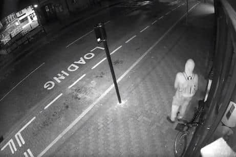 Image shows he burglar loitering around outside the premises before breaking in to steal the cash till