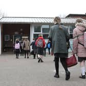 Children arrive at a school.