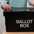 File photo of a person putting a vote into a ballot box