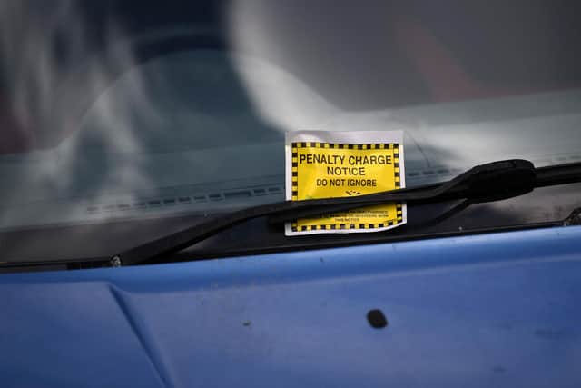 A Penalty Charge Notice (PCN) or parking ticket is pictured attached to the windscreen of a van  (Photo by DANIEL LEAL/AFP via Getty Images)