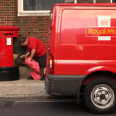 A Royal Mail employee empties a post box in Southwark.  (Photo by Oli Scarff/Getty Images)