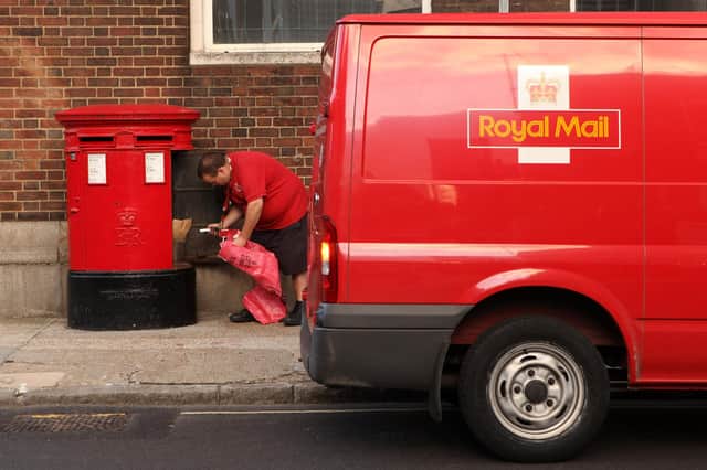 A Royal Mail employee empties a post box in Southwark.  (Photo by Oli Scarff/Getty Images)