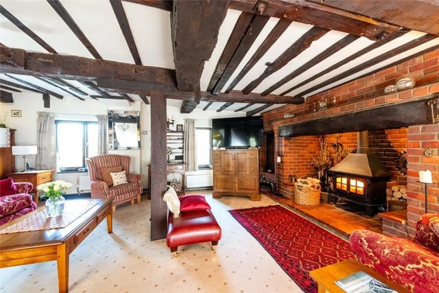 A feature brick inglenook fireplace has a tiled hearth and houses a lob burning stove. There is a built-in log store on one side of the fireplace and a built-in broom cupboard on the other side.