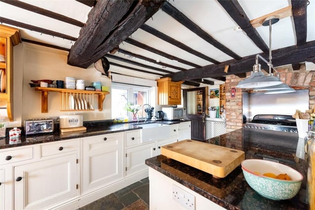 The kitchen has a range of handmade units which include display shelving and plate racks, a larder cupboard, and a central island all with granite work surfaces which incorporate a butlers sink. Integrated appliances include a dual fuel range cooker with a six ring gas hob in a brick chimney recess