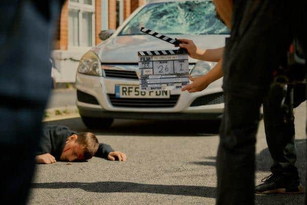 Big stunt! Actor Sonny Middleton gets up after being hit by a stunt car.