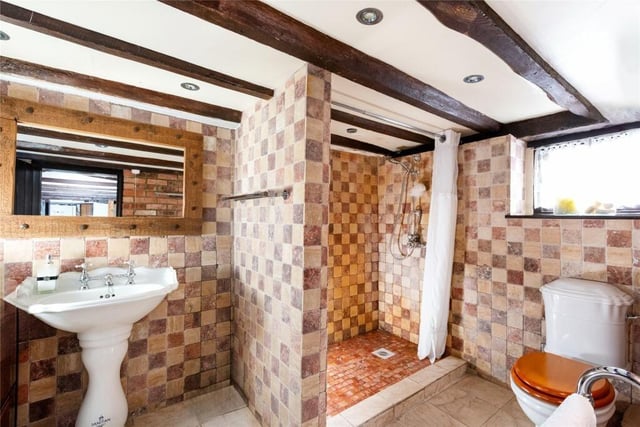 This shower room is on the ground floor. It boasts marble tiling, feature brick walls and a walk-in shower. There's another bathroom
