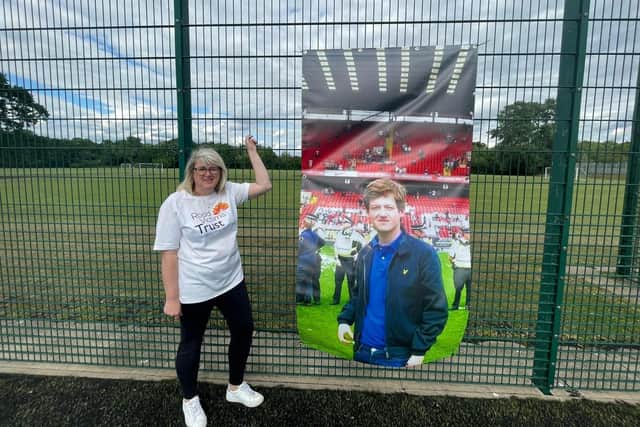 Wendy stands proudly next to a poster of her son, Jamie. Image: Wendy Parker.