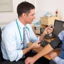 File photo of a doctor taking a man's blood pressure