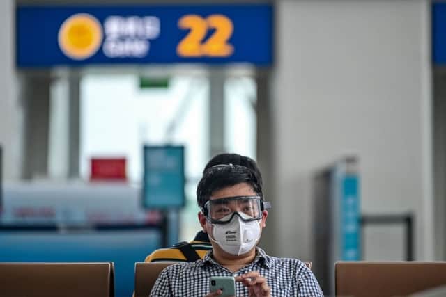A passenger wearing a facemask and goggles sits as he waits for his flight at Tianhe Airport in Wuhan (Photo: Getty)
