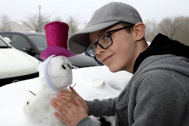 Dylan Ireland puts a hat on a snowman at the Wear a Hat Day launch, 2018, at MK HQ. Photo by Jake McNulty