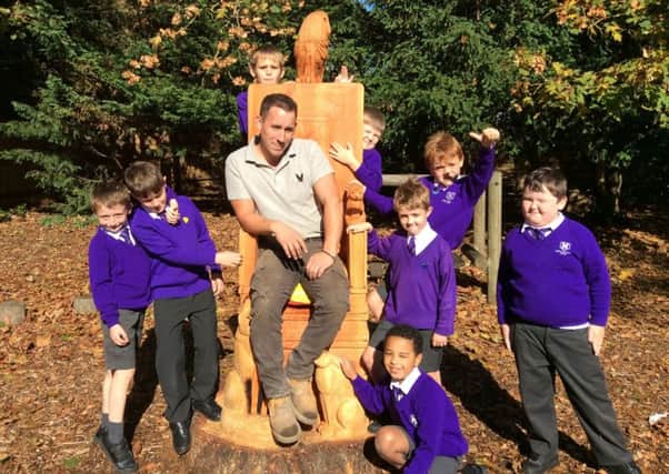 Tom and excited Heathwood pupils admire the new storytelling chair.