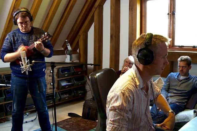 Creating the film: Leighton-Linslade musician John Tubby plays his ukelele as Stuart monitors the recording on the computer. Directors, Joanna and Robin, look on from behind.