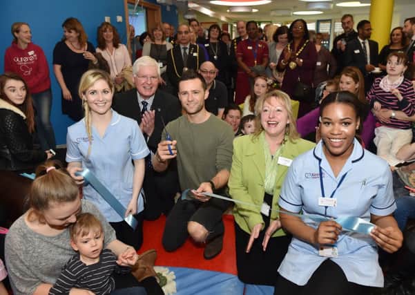 McBusted's Harry Judd cuts the blue ribbon at the opening of Keech Hospice Care's new children's unit