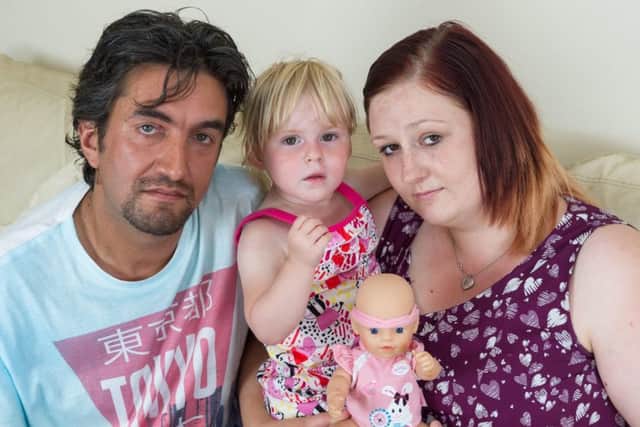 Anthony Burridge and Sarah Williams with their daughter Emily and her baby doll toy which 'swears'. Photo: SWNS