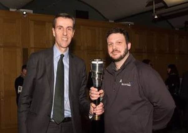 Andrew Selous MP and apprentice James Hays  with the Torch of Knowledge at the House of Commons PNL-160217-164725001