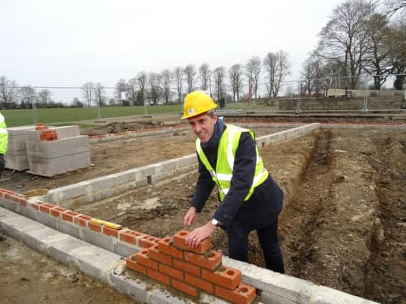 Andrew Selous lays the first brick at the railway