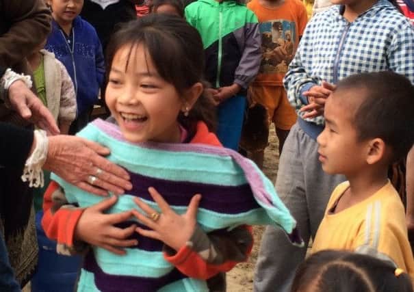 A little Lao girl expresses her joy at getting a jumper