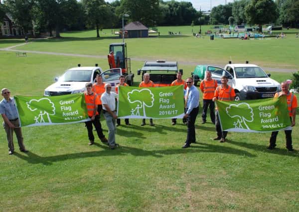 Town clerk Mark Saccoccio, Cllr Stephen Jones, and Cllr Clive Palmer hold the newly awarded flags alongside some of the grounds team.