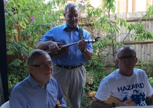 A trio from Ukie Toones entertained guests at an MND barbecue before presenting the charity with a cheque for Â£1,550