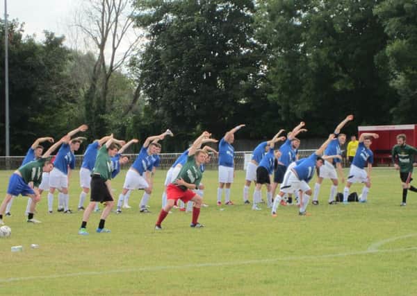 Football teams take part in jazzercsie before the match at KidsOut's inaugural family fun day in Leighton Buzzard