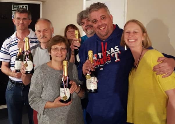 Quiz winners celebrate their success with glasses of bubbly. They raised Â£600 for KidsOut and Braest Cancer Now
