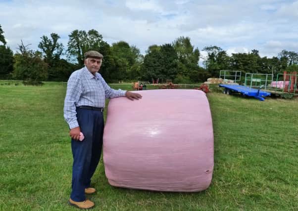 Farmer Evan Kempster who is helping to raise money for breast cancer by wrapping his bales in pink wrapper