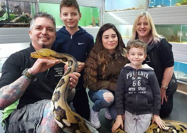 Julian (left) introduces customers to reticulated python, Grace