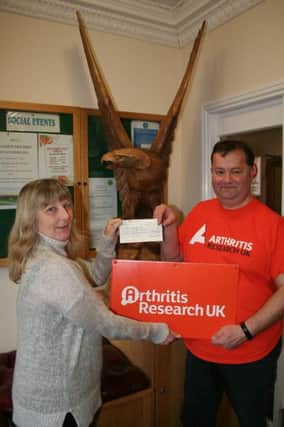 GIFT AID&.Angela Samuels presents a cheque to Adrian Williams to help people suffering from arthritis.